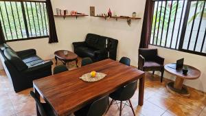 a living room with a wooden table and chairs at Casa Escondida in Cahuita