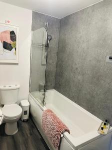een badkamer met een bad, een toilet en een douche bij Hotel Feel, Home Comfort in Manchester