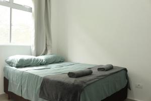 a bed with two pillows on it in a bedroom at Apto completo e bem localizado em araucária in Araucária +5 photos