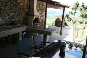 un patio con mesa, sillas y chimenea en Casa da Avó, en Armamar