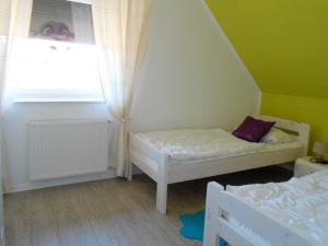a small room with two beds and a window at Seaview & Sunside in Grömitz