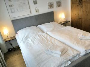 ein großes weißes Bett in einem Schlafzimmer mit zwei Lampen in der Unterkunft Villa Heimkehr Apartment 02 in Göhren