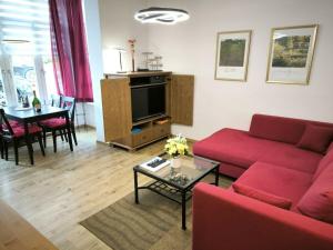 ein Wohnzimmer mit einem roten Sofa und einem Tisch in der Unterkunft Villa Heimkehr Apartment 02 in Göhren