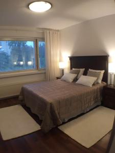 a bedroom with a large bed with a large window at City Apartment Sairaalakatu in Kuopio
