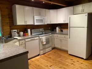a kitchen with white appliances and white cabinets at Private Cozy 3 BR Cabin near Mt Rainier, Sunrise & Crystal Mt Hiking in Greenwater +20 photos