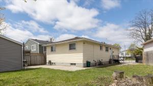 a white house with a fence in a yard at Stewarts Place Newly Renovated Basement City Apartment in Hamilton