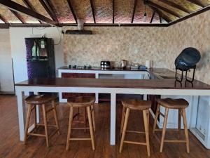 a kitchen with a large white counter top and stools at Wind & Sea Lakey Peak in Huu