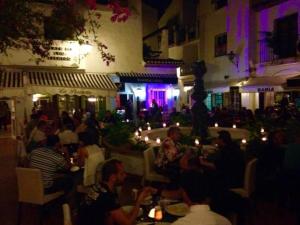 un gruppo di persone sedute in un ristorante di notte di La Nogalera Experience a Torremolinos Altre 132 foto