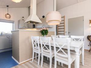 a kitchen with a white table and white chairs at 6 person holiday home in Hjørring in Hjørring