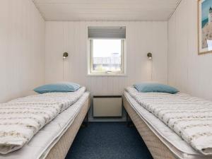 two twin beds in a room with a window at 6 person holiday home in Hjørring in Hjørring