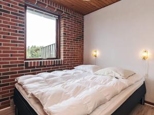 a large bed in a room with a brick wall at 7 person holiday home in Frøstrup in Frøstrup
