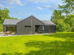 a black house with a large yard at 10 person holiday home in Glesborg-By Traum in Glesborg