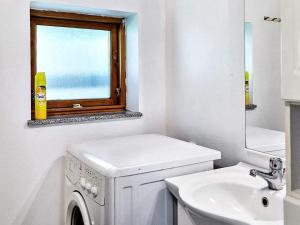 baño blanco con lavadora y lavamanos en Tranquil Seaside Haven-By Traum, en Store Fuglede