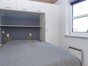 ein Schlafzimmer mit einem Bett mit schwarzen und weißen Streifen in der Unterkunft 6 person holiday home in Fanø-By Traum in Fanø
