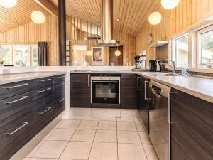 une grande cuisine avec des armoires en bois et une cuisinière dans l'établissement Luxury Retreat in Klitmoller - By Traum Ferienwohnungen, à Torsted