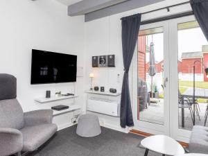 a living room with a tv and a couch and a chair at 6 person holiday home in Hadsund-By Traum in Hadsund