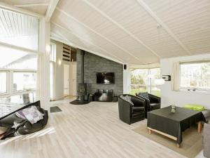 Elle comprend un salon doté d'un mobilier noir et d'une cheminée. dans l'établissement Modern Retreat with Sauna - By Traum Ferienwohnungen, à Blåvand