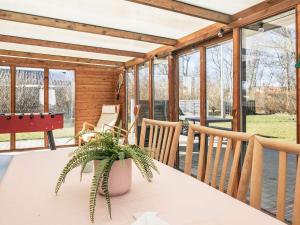 a screened in porch with a table and chairs at 8 person holiday home in Vinderup-By Traum in Vinderup +29 photos