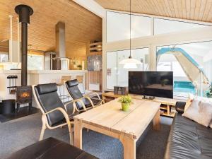 un salon avec une table et une télévision dans l'établissement Luxury Pool House Retreat - By Traum Ferienwohnungen, à Saltum