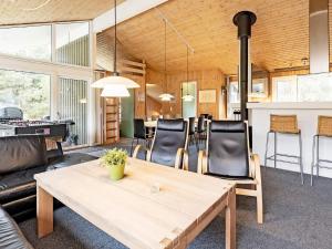 un salon avec une table et des chaises en bois dans l'établissement Luxury Pool House Retreat - By Traum Ferienwohnungen, à Saltum