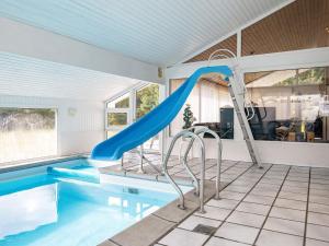 une piscine avec toboggan dans une maison dans l'établissement Luxury Pool House Retreat - By Traum Ferienwohnungen, à Saltum
