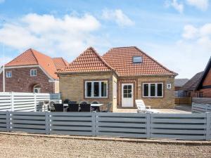 una casa con una valla blanca delante en 6 person holiday home in Højer, en Højer