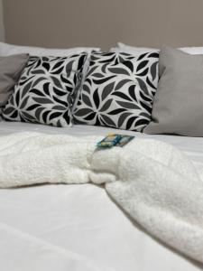 ウベラバにあるComforto-1 min ABCZl 4 min BR050の白いローブが掛けられたベッドのクローズアップ