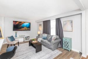 a living room with a couch and a table at Quaint and Stylish UPPER level 3-bed bungalow in Hamilton, ON in Hamilton