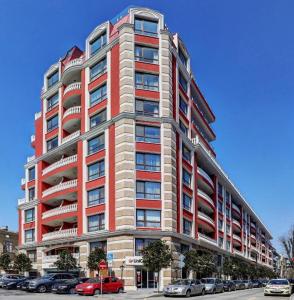 a tall building with cars parked in front of it at Grand Karavel - Luxury Central 1BR + Parking in Varna City