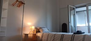 a bedroom with a bed and a lamp and a window at CarriCHe 2 in Lisbon