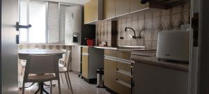 a kitchen with a sink and a table and chairs at CarriCHe 2 in Lisbon