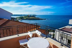 a balcony with a table and chairs and the ocean at Villa Maria in Tsarevo