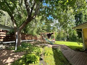 un parco giochi con albero e altalena di Natural Cottage a Kauniainen
