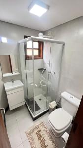 ein Badezimmer mit Glasdusche und Toilette in der Unterkunft Condomínio Village do Araripe - Casa Brisa da Serra in Gravatá