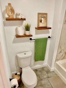 a bathroom with a toilet and a green towel at Spacious 3BR Apartment - 12min Newark Airport -Near NYC & Malls in Newark