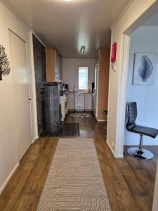 a living room with a chair and a kitchen at Small cottage in Toholampi +8 photos