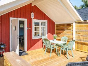 a patio with a table and chairs on a wooden deck at 4 person holiday home in LÖTTORP-By Traum in Löttorp +6 photos