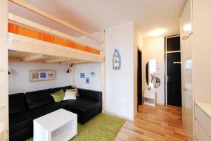 a living room with a black couch and a loft bed at Apartment Doris in Šibenik