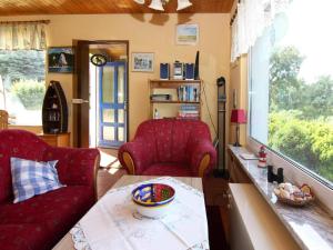 a living room with two red chairs and a table at Wunderschönes Ferienhaus am Schilfufer in Barth in Barth