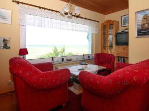 a living room with red chairs and a table and a window at Wunderschönes Ferienhaus am Schilfufer in Barth in Barth