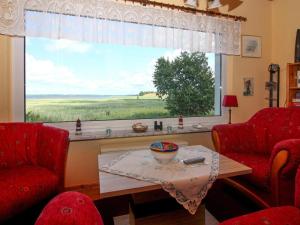 a living room with a table and a large window at Wunderschönes Ferienhaus am Schilfufer in Barth in Barth +22 photos