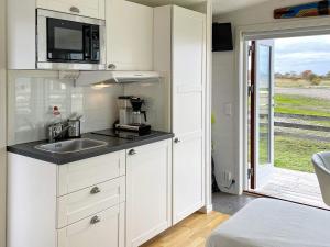 a kitchen with white cabinets and a sink and a window at 3 person holiday home in LÖTTORP-By Traum in Löttorp +16 photos
