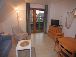 un salon avec un canapé et une télévision dans l'établissement Cozy Holiday Apartment on Fehmarn, à Petersdorf auf Fehmarn