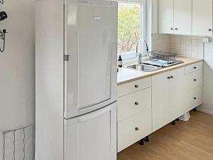 a white kitchen with a refrigerator and a sink at 4 person holiday home in Södertälje-By Traum in Södertälje