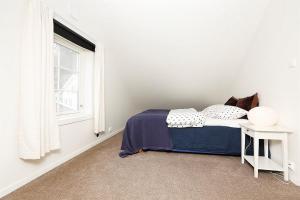 a white bedroom with a bed and a window at Mandal Privat Romutleie in Mandal