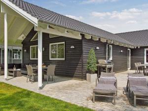 a covered patio with chairs and a grill at 20 person holiday home in Hasselberg in Kappeln +22 photos
