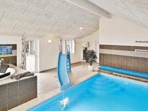 a indoor swimming pool with a slide in a house at 20 person holiday home in Hasselberg in Kappeln