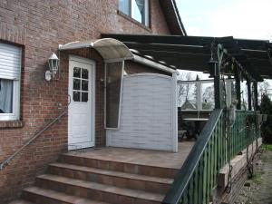 eine Tür an der Seite eines Backsteinhauses mit einer Treppe in der Unterkunft Ferienwohnung Am Bach in Rees