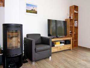 a living room with a chair and a television at Haus in Vieregge am Breetzer Bodden in Vieregge