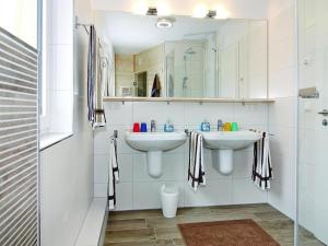 a white bathroom with two sinks and a shower at Haus in Vieregge am Breetzer Bodden in Vieregge +6 photos